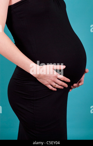 Schwangere Frau die Hände auf den Bauch Stockfoto