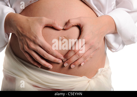 Schwangere Frau, Herzform mit Händen über ihren Bauch isoliert auf weißem Hintergrund Stockfoto