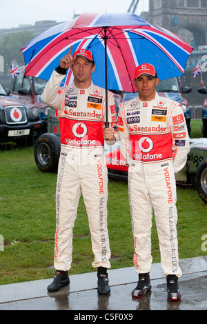 Der ehemalige Formel-1-Weltmeister Jenson Button und Lewis Hamilton an einem Fotoshooting im strömenden Regen in London Stockfoto