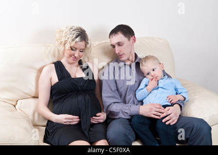 Schwangere Frau mit ihrer Familie zu Hause auf Sofa saß Stockfoto