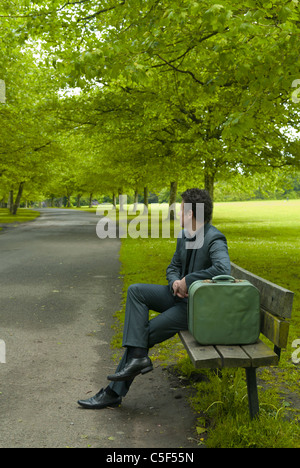 Mann mit seiner Tasche saß im Park entspannen Stockfoto