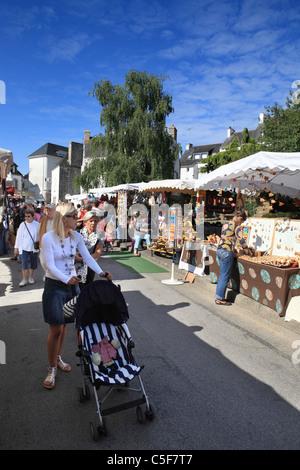 Junge Frau schieben Kinderwagen durch Carnac Markt, Bretagne, Frankreich Stockfoto