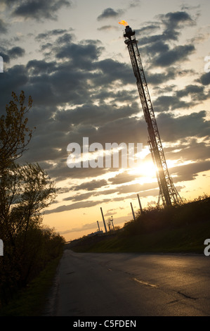 dunkle Straße neben Öl-Raffinerie in der Abenddämmerung Stockfoto