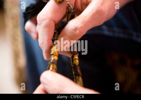 Mann vorbei Komboloi durch Hände Stockfoto