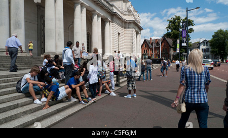 Eine Gruppe französischer Studenten, Jugendliche, die auf den Stufen vor dem National Museum of Wales auf einer Schulreise im Sommer nach Cardiff, Wales, Großbritannien, KATHY DEWITT, sitzen Stockfoto