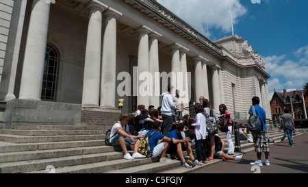 Ausländischen Schulgruppe von Jugendlichen sitzen auf den Stufen vor dem National Museum of Wales auf einer Klassenfahrt Cardiff, Wales UK KATHY DEWITT Stockfoto