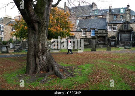 Ein junges Paar vorbei Grabsteine und Häuser n Greyfriars Kirkyard Kirchhof im Herbst Edinburgh Schottland KATHY DEWITT Stockfoto