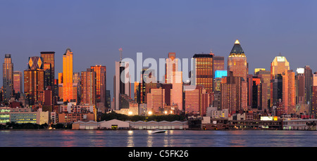 New York City Manhattan Sonnenuntergang Panorama mit historischen Wolkenkratzern über Hudson River mit schönen roten Farbe Sonnenschein Reflexion von New Jersey Weehawken Waterfront angesehen. Stockfoto