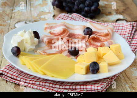 Snack-Käseplatte mit Trauben und Speck Stockfoto