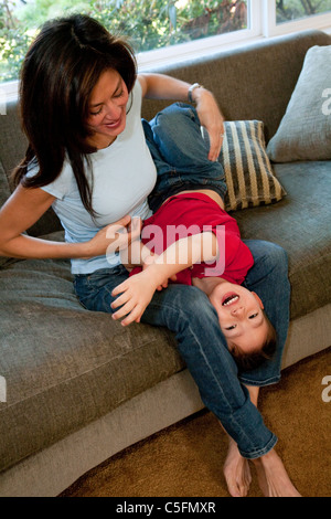 Mutter und Sohn spielt auf der couch Stockfoto