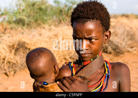 Porträt eines Hamer Mädchen und Kind in einem Dorf in der Nähe von Turmi am unteren Omo-Tal, Südliches Äthiopien, Afrika. Stockfoto