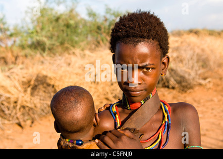 Porträt eines Hamer Mädchen und Kind in einem Dorf in der Nähe von Turmi am unteren Omo-Tal, Südliches Äthiopien, Afrika. Stockfoto