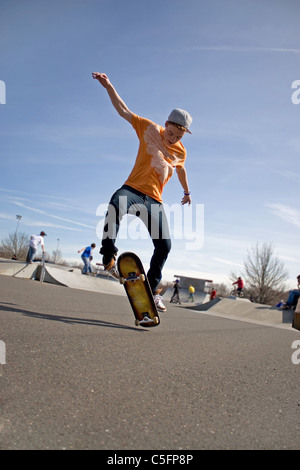 Ein Junge Skateboarder einen Stunt in einem Skatepark zu tun. Stockfoto