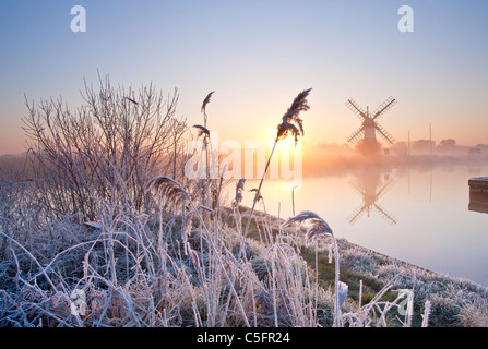 Thurne Windmühle bei Sonnenaufgang an einem Winter-Morgen nach einer Nacht Raureif auf den Norfolk Broads Stockfoto