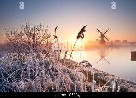 Thurne Windmühle bei Sonnenaufgang an einem Winter-Morgen nach einer Nacht Raureif auf den Norfolk Broads Stockfoto