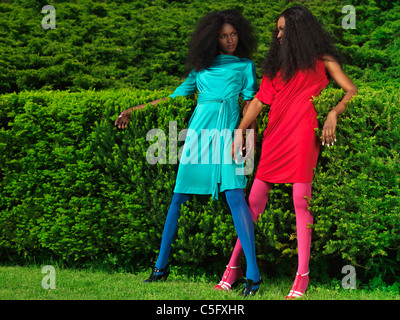 Führerschein erhältlich unter MaximImages.com - zwei schöne junge Frauen in leuchtend bunt gekleidet in einem grünen Park Stockfoto