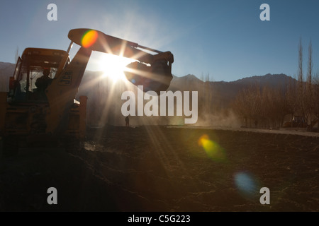 Bagger entfernen Felsbrocken aus dem Land, das in den Fluten des Jahres 2010 getroffen wurde. Schutt fiel aus den Bergen auf fruchtbaren Boden. Stockfoto