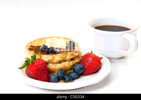 Waffeln, Erdbeeren, Heidelbeeren und Butter mit Tasse Kaffee.  Frühstück isoliert auf weißem Hintergrund. Stockfoto