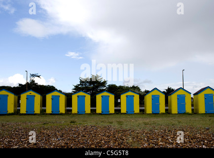 Strandhütten unter Regenwolken in Littlehampton, West Sussex Stockfoto