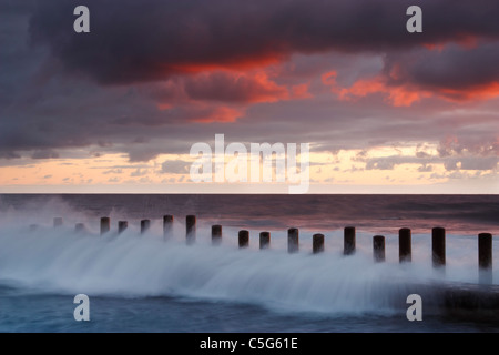 Wellen brechen über Beiträge schützen Küsten Schwimmbäder an der Nordküste von Gran Canaria Stockfoto