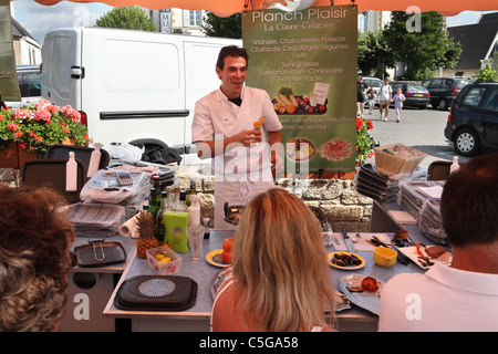 Ein Verkäufer verkaufen Europoêles Kochgeräte auf einem Marktstand in der Bretagne Carnac, Frankreich Stockfoto