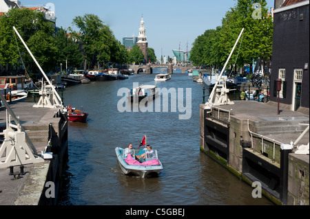 Boote, die entlang einer Brücke an einer Gracht in Amsterdam. Stockfoto