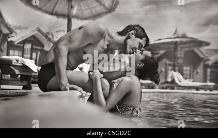 Junge Paar küssen in einem Schwimmbad Stockfoto