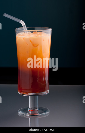 Thai Eistee in ein hohes Glas mit Sahne und einem Strohhalm serviert. Stockfoto