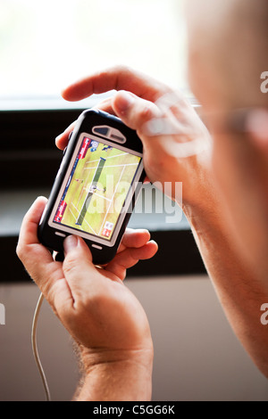 Mann auf dem Iphone spielen Stockfoto