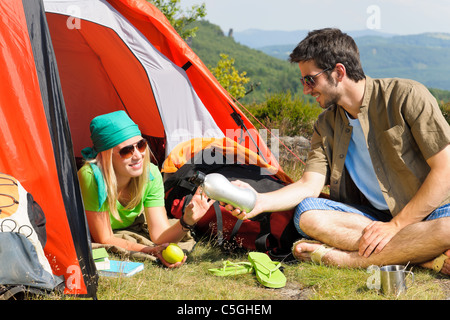 Brautpaar camping mit Zelt Rucksack in sonniger Landschaft Stockfoto