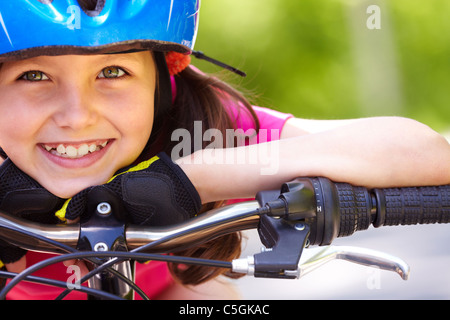 Nahaufnahme eines kleinen Mädchens Gesichts auf Fahrrad Blick in die Kamera und lächelnd Stockfoto