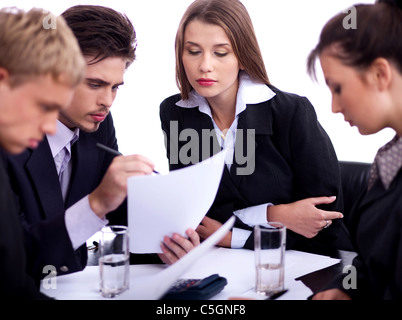 Junge Berufstätige Geschäftsleute diskutieren ernsthaft in ihrer Sitzung mit Dokumenten auf weißem Hintergrund Stockfoto