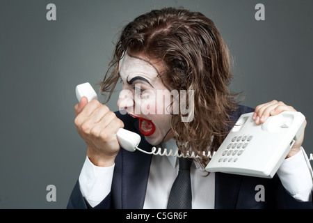 Porträt der Geschäftsmann mit theatralischen Make-up am Telefonhörer schreien Stockfoto