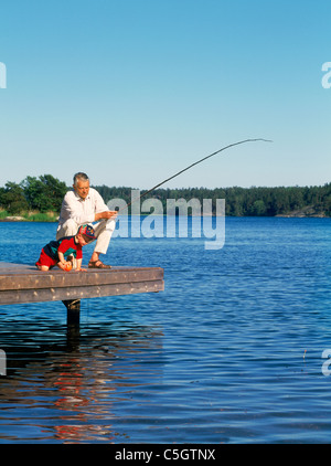 Großvater mit Enkel aus hölzernen Dock entlang Ostsee Küste im schwedischen Sommer Angeln Stockfoto