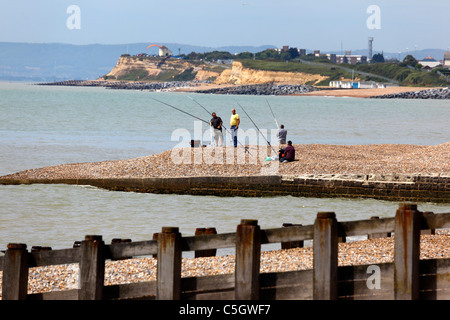 Männer fischen vom Kiesstrand aus, Galley Hill im Hintergrund, St Leonards on Sea, East Sussex, England Stockfoto