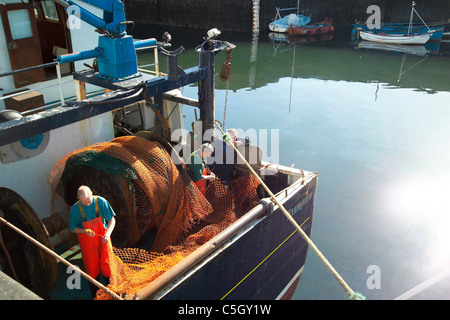 Fischer und Fischerboot bei der Arbeit im Hafen von Eyemouth Stockfoto