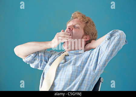 Mann sitzend Gähnen Stockfoto