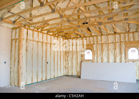 Ein Zimmer in einem neu errichteten Haus versprüht mit Flüssigkeit Isolierschaum, bevor die Trockenmauer hinzugefügt wird. Stockfoto