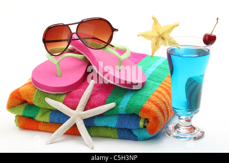 Strandzubehör mit Handtuch, Flip-Flops, Sonnenbrillen und ein Glas Cocktail. Isoliert auf weißem Hintergrund. Stockfoto
