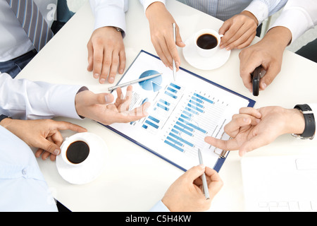 Bild von Menschenhand mit Stiften über geschäftliche Dokumente der Tagung Stockfoto