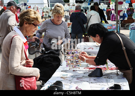 Frauen in Führungspositionen Kauf Schmuck am Marktstand in Etretat, Normandie, Frankreich Stockfoto