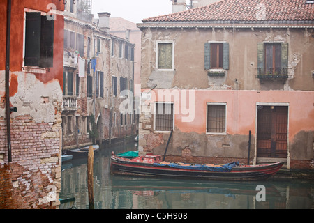 Ein Boot vor Anker an einem Kanal neben einem alten Gebäude, Venedig, Italien Stockfoto