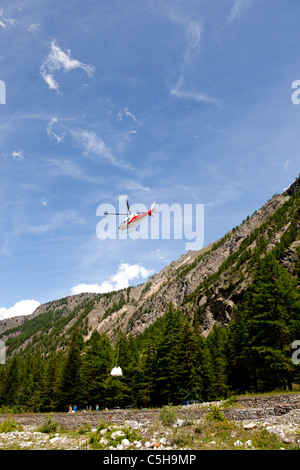 Ein Liftbetrieb von einem Hubschrauber in eine Moutainous Site (Aostatal - Italien).  Opération de Levage de Montagne Par Hélicoptère. Stockfoto