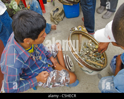 Ein Mann verkauft alte Amulette, Münzen und andere Sachen auf dem Wai Khru Festival von Wat Bang Phra Stockfoto