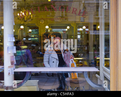 Paris, Frankreich, Frau im Schaufensterfenster in der Old French Bakery, Boulangerie, im Marais, 'Le Petit Versailles » Schild Stockfoto