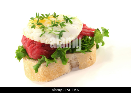 CANape mit Salat, Tartar, Spiegelei und Brunnenkresse auf weißem Hintergrund Stockfoto