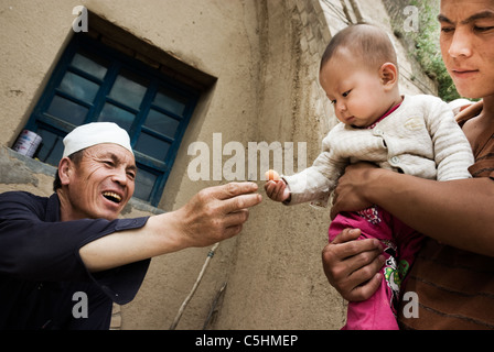 Bauer eine untermaßige Aprikose verleiht seinem Enkelkind, Ningxia, china Stockfoto