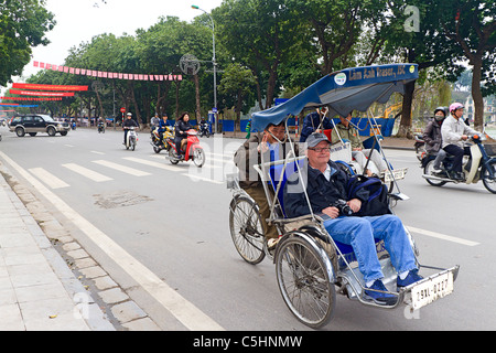 Touristen nehmen Cyclo Tour im historischen Viertel von Hanoi, Vietnam. Diese Fahrrad-Rikschas Gefahren sind bei Touristen sehr beliebt. Stockfoto