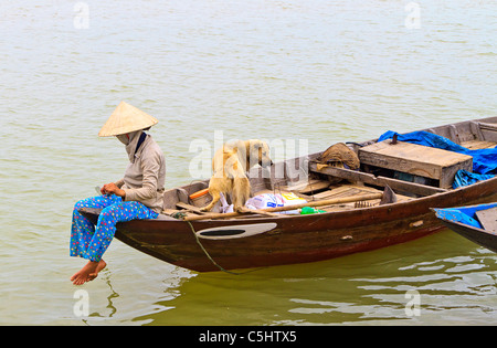 Mann macht seinen Weg Thu Bon Fluss hinunter in traditionellen Boot, Hoi An, Zentral-Vietnam. Stockfoto