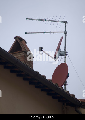 Sat-TV Gerichte stehen im Kontrast zu älteren Häusern in Cortona, Italien Stockfoto